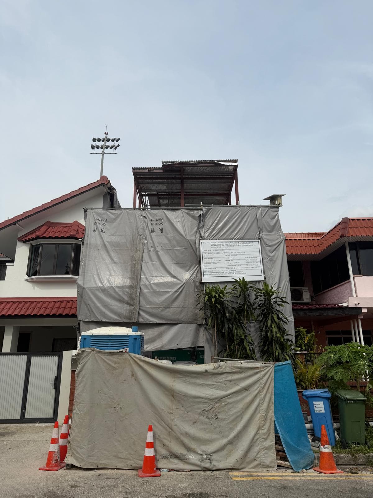 Existing west-region landed house frontage with hoarding and active structural works in progress.